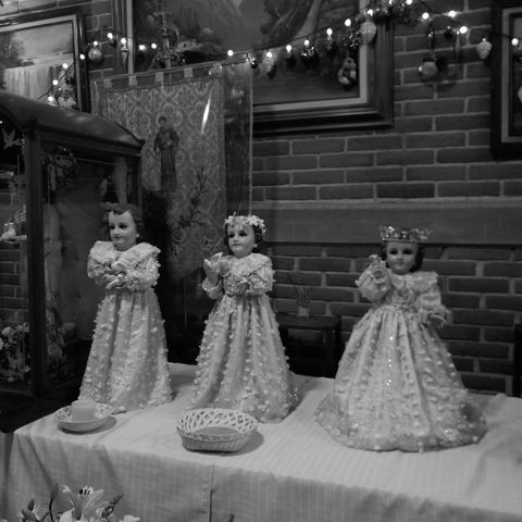 Detalle de la mesa principal de un bautizo con figuras vestidas de blanco
